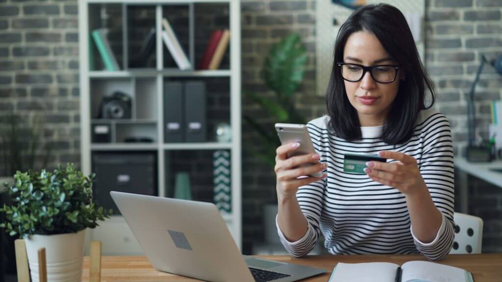 a-woman-sitting-at-a-table-looking-at-her-cell-phone-1jnn9qhmtgu-1024x576-ntxwn78LXtpXWYSDlyoj