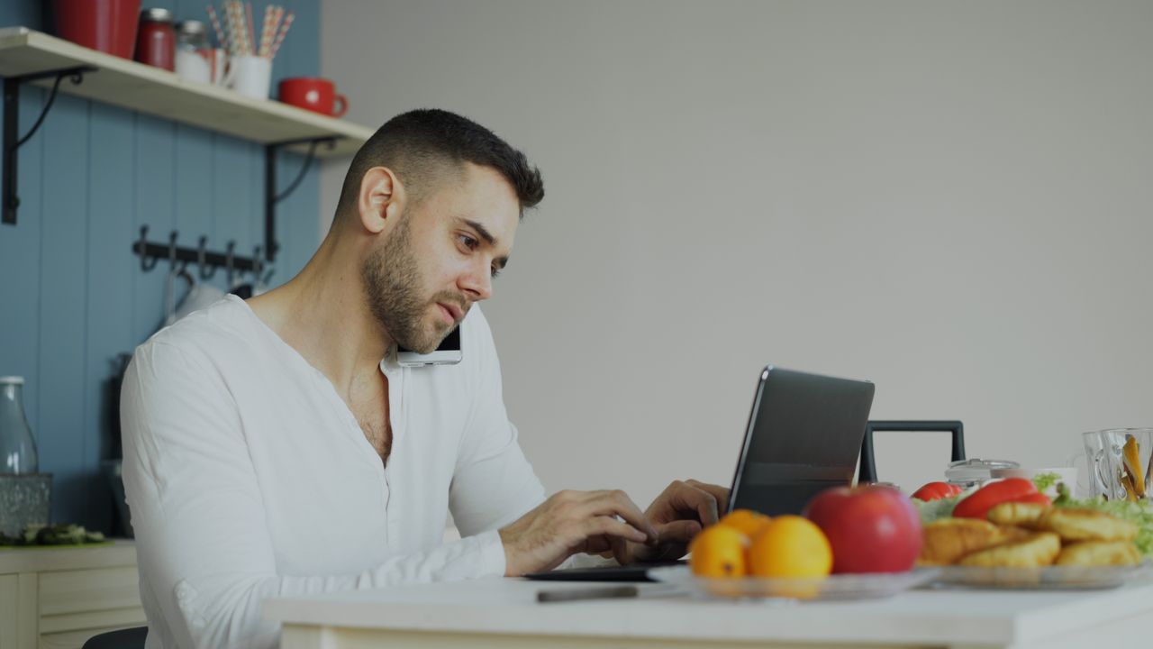 man-working-remotely-in-kitchen-with-laptop-36763311-4ndBSfPRVUBVSKRqiQCF