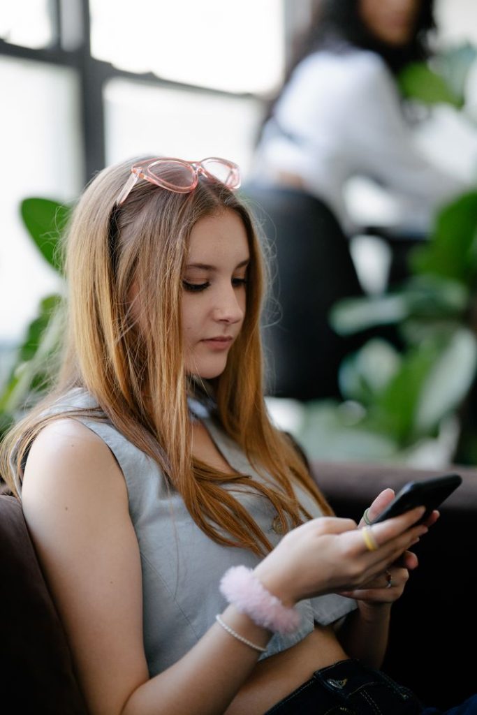 woman-with-brown-hair-holding-cellphone-13929450-IwThnskNOtWLES59hfAq
